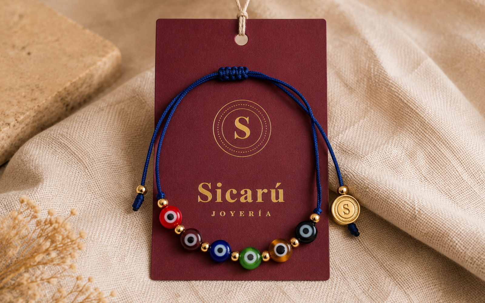 Prototipo conceptual de pulsera y medallón Sicarú sobre tarjeta de marca